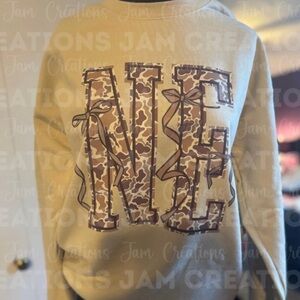 Medium Gildan Beige Nebraska Sweatshirt with Camo NE letters and bows